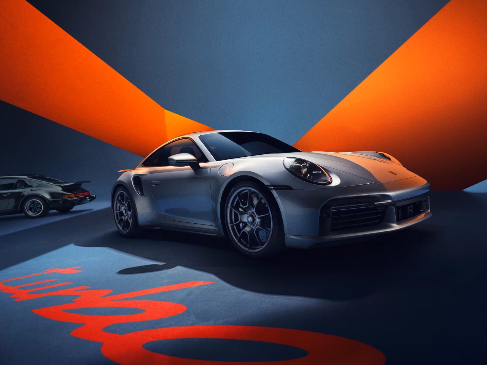 The Porsche 911 Turbo 50 Years in GT Silver Metallic is shown from the side and from the front.