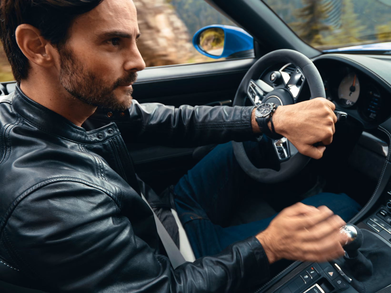 Foto do interior de um Porsche 718 Boxster GTS 4.0 com foco no motorista e no volante.