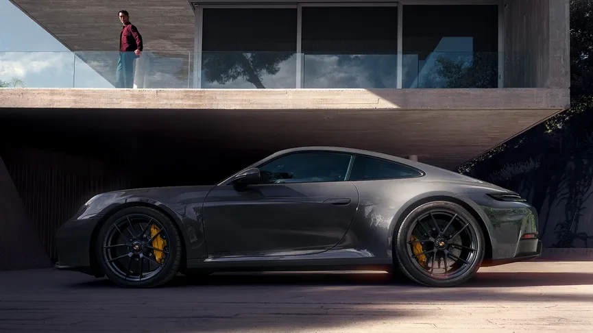 A high-angle shot shows a grey 911 Carrera GTS, parked in front of a minimalist modern house.