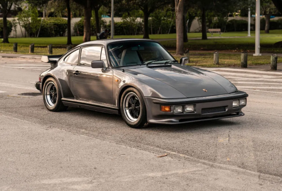 Ein Porsche 911 Turbo von 1982 mit der speziellen "Flatnose"-Karosserie vor einem Park. 
