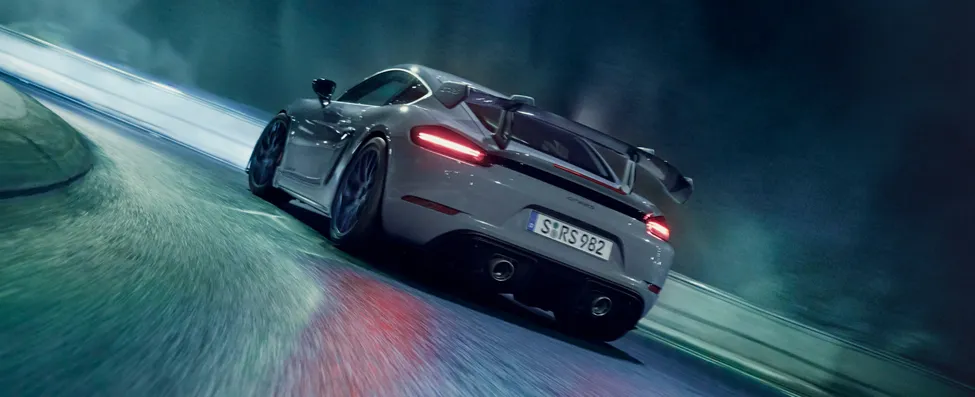 Porsche 718 Cayman GT4 RS серого цвета (Arctic Grey) с пакетом «Вайсах» едет по туннелю. Вид на заднюю часть.