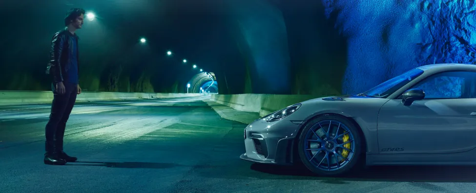 Porsche 718 Cayman GT4 RS en color Gris Arctic con paquete Weissach en un túnel. Vista de la parte delantera desde el lateral.