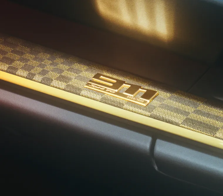 Detailed view of the gold-colored limited edition badge with '911' lettering on the decorative trim of the dashboard of the Porsche 911 Spirit 70.
