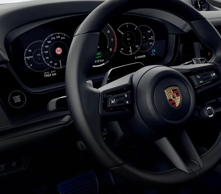 Innsyn i cockpiten i Porsche Cayenne Black Edition med fokus på rattet.