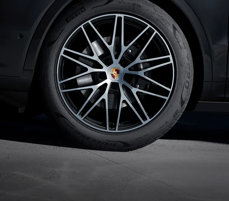 Detailed view of the 21-inch RS Spyder Design wheel in Black (high-gloss) on the Porsche Cayenne Black Edition in Chromite Black Metallic.