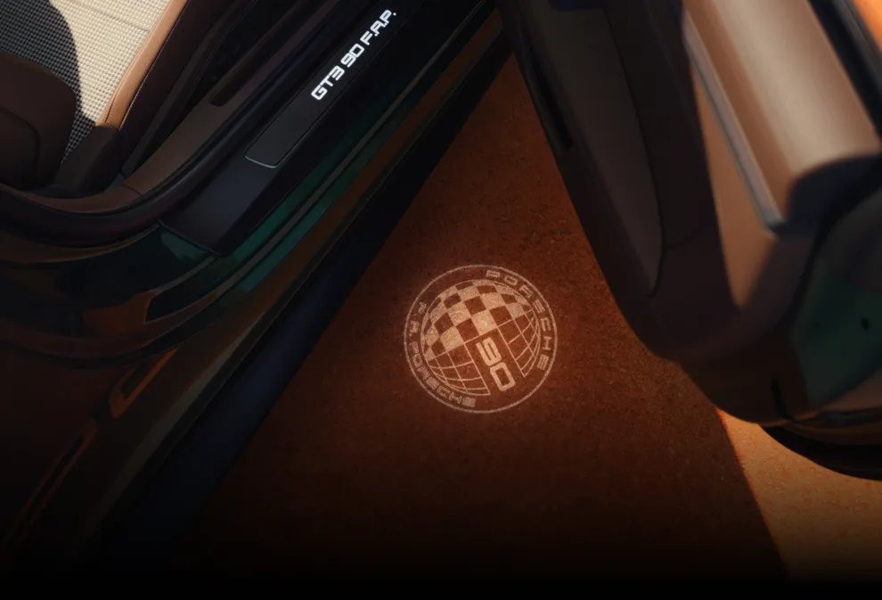 Projection of the Porsche 911 GT3 90 F. A. badge on the floor with the door open.