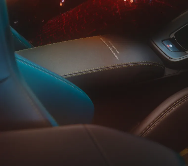 Szczegółowy widok pokrywy schowka z wytłoczonym napisem „PORSCHE Exclusive Manufaktur” w konsoli środkowej Porsche 911 Spirit 70.