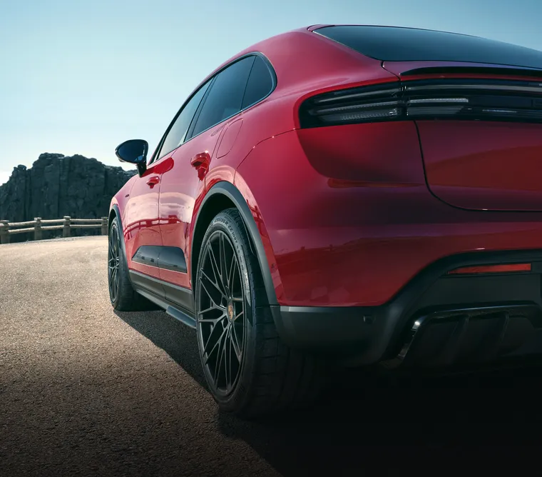 View of the rear end and part of the side of a Porsche Macan GTS Electric in Carmine Red.