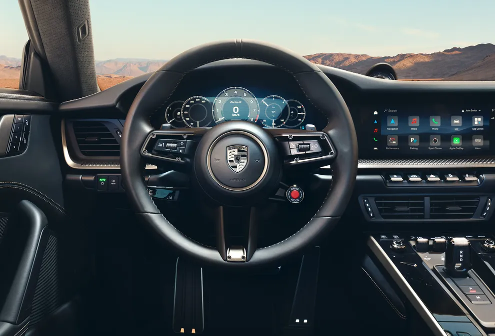 Detailed view of the GT Sport steering wheel with Porsche Crest in Turbonite on the Porsche 911 Turbo S.