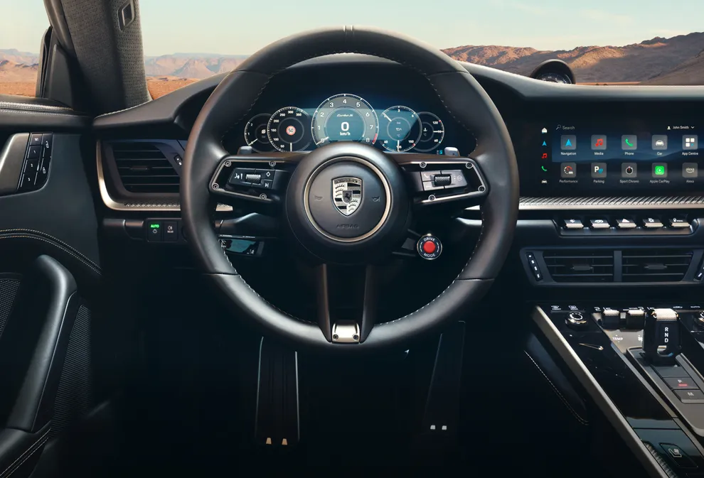 Detailed view of the GT Sport steering wheel with Porsche Crest in Turbonite on the Porsche 911 Turbo S.