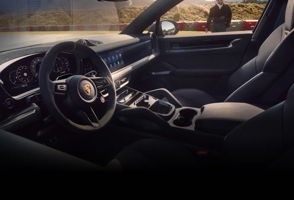 Interior del Porsche Cayenne Turbo E-Hybrid Coupé con paquete GT: vista del puesto de conducción a través de la ventana.