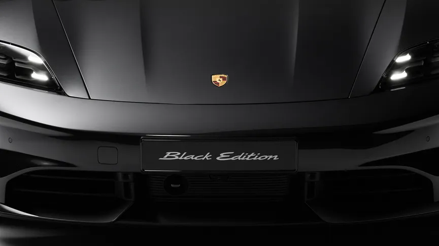 Mehrere Porsche Taycan Black Edition Modelle in Tiefschwarzmetallic stehen nebeneinander.