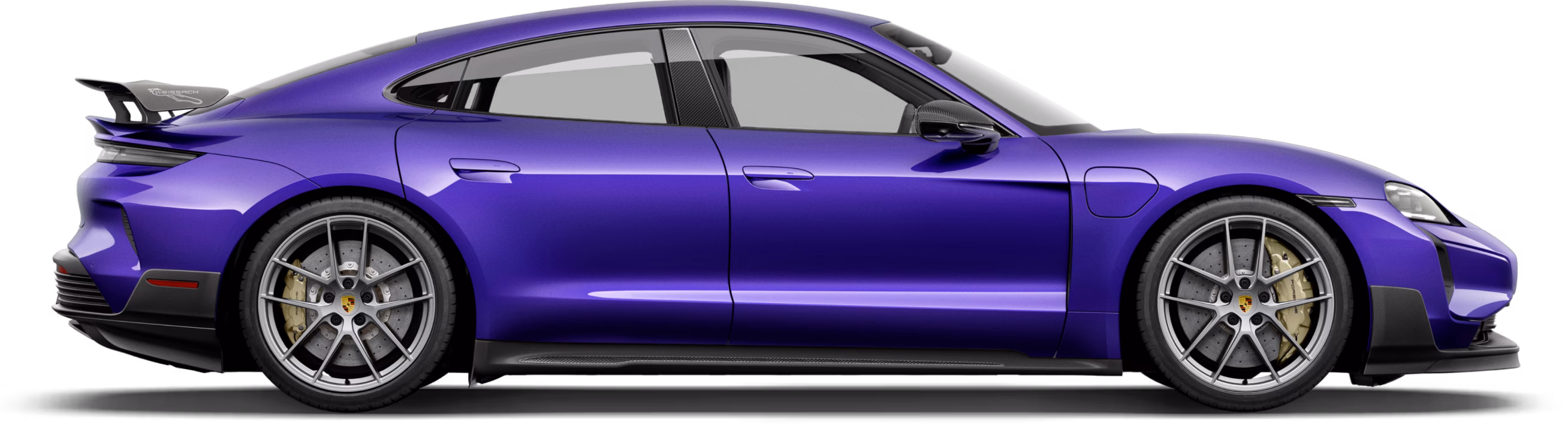 Side view of a metallic purple four-door sports sedan with low profile, alloy wheels and a rear spoiler.