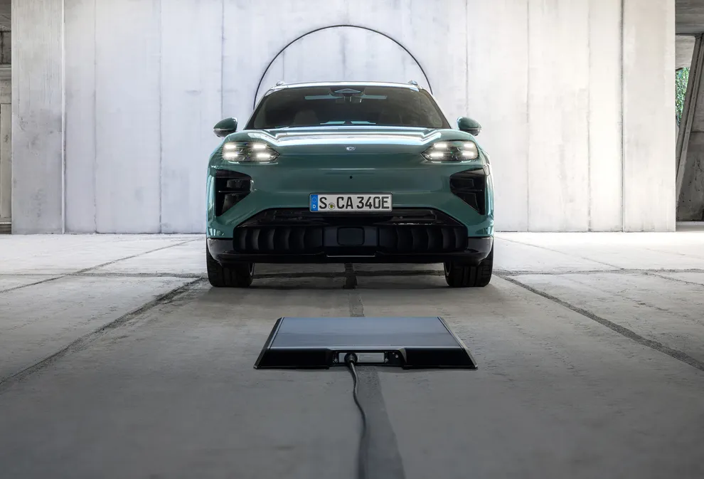 Ein Porsche Cayenne Turbo lädt auf einer induktiven Ladeplatte.