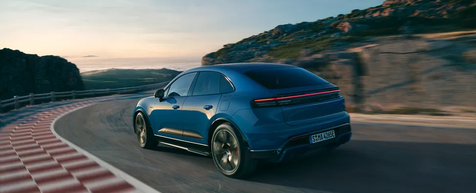View of the rear end of a moving Porsche Macan GTS in Lugano Blue.