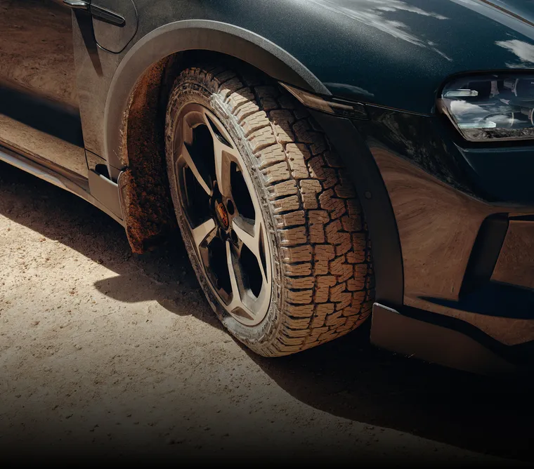 Detailansicht eines 20-Zoll Offroad Design Rads mit All-Terrain-Reifen am Porsche Taycan Cross Turismo mit Adventure Zubehör.