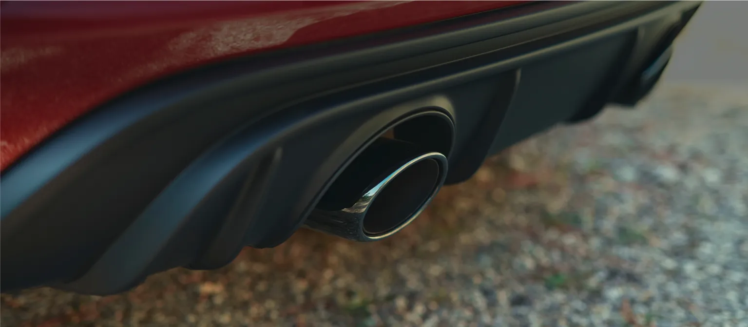 Driving shot of a Porsche 718 Cayman GTS 4.0 in Carmine Red. View of the rear end.