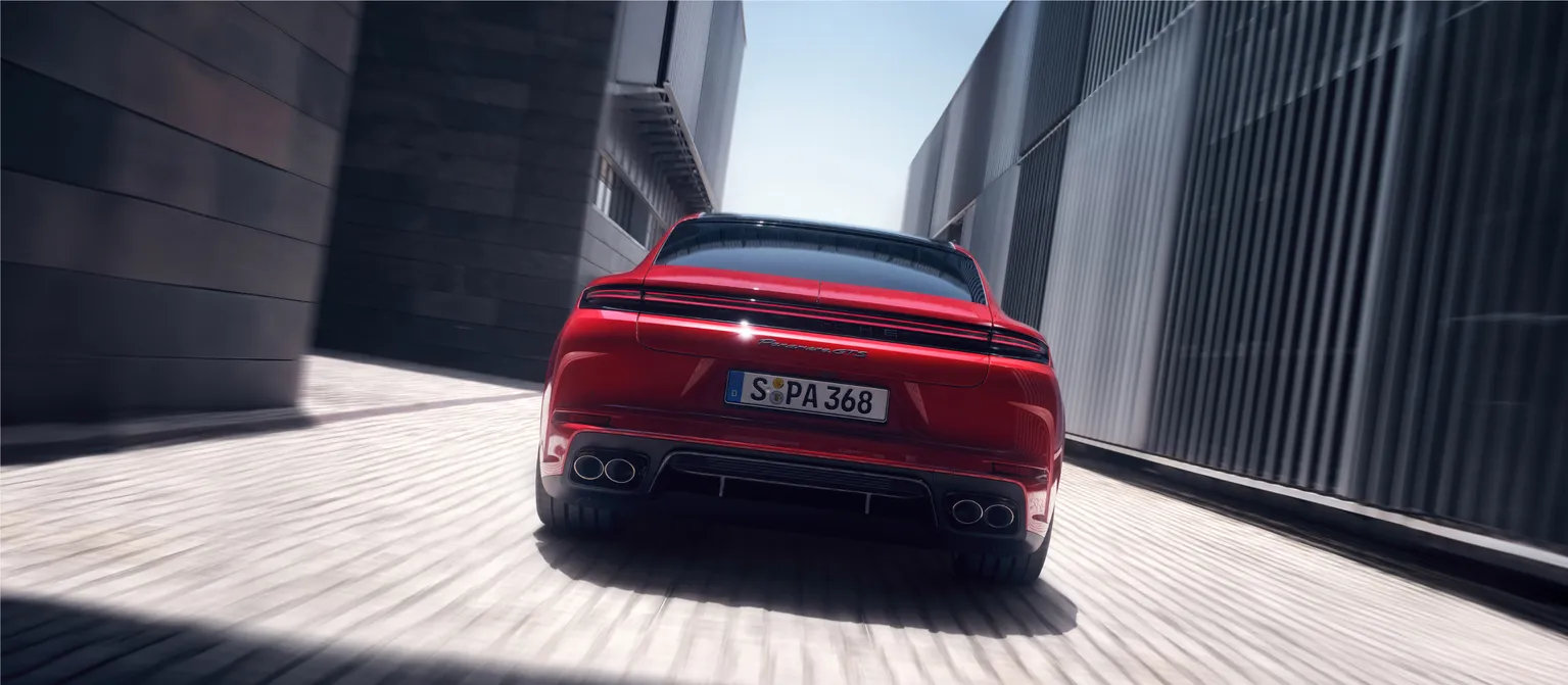 Porsche Panamera GTS in Carmine Red on a street. View of rear end from behind.