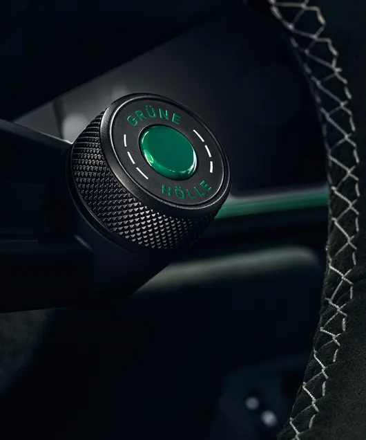 Detailansicht des "Grüne Hölle"-Knopfes am Lenkrad des Porsche 911 GT3 100 Jahre Nürburgring.