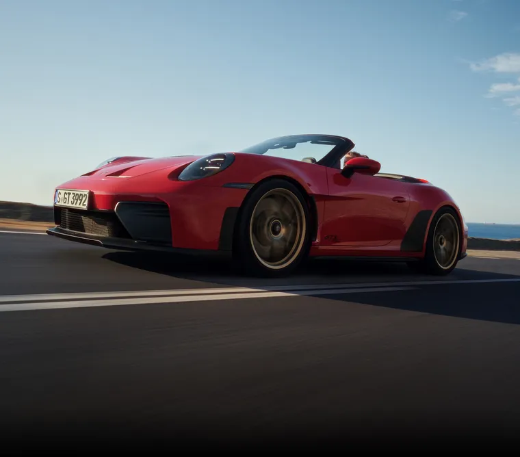 Side view of a Porsche 911 GT3 S/C in Guards Red driving on a country road.