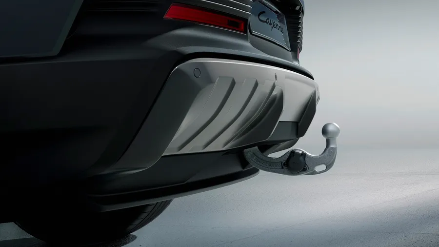 Detailed view of the extended trailer hitch at the rear end of a Porsche Cayenne.