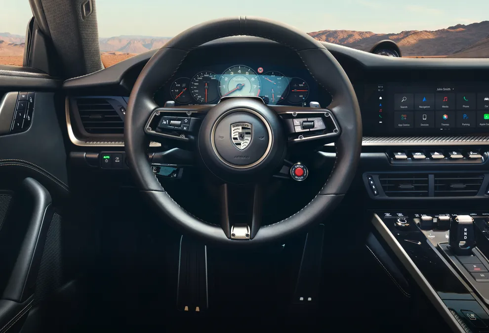 Detailed view of the GT Sport steering wheel with Porsche Crest in Turbonite on the Porsche 911 Turbo S.