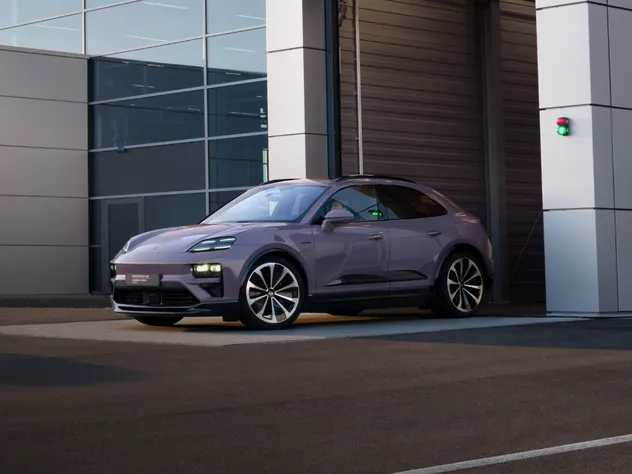 Porsche Macan 4 in Lackierung Provence steht vor der Garage eines Porsche Autohauses.