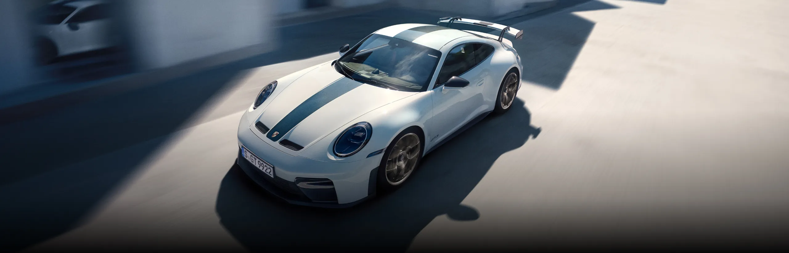 Blick auf Front und Seite eines fahrenden Porsche 911 GT3 in Weiß mit Weissach-Paket.