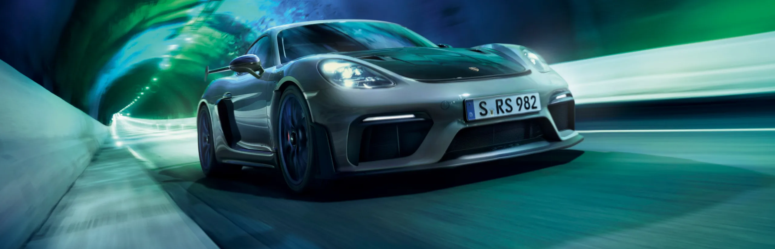 Porsche 718 Cayman GT4 RS en color Gris Arctic con paquete Weissach atravesando un túnel. Vista de la parte delantera.