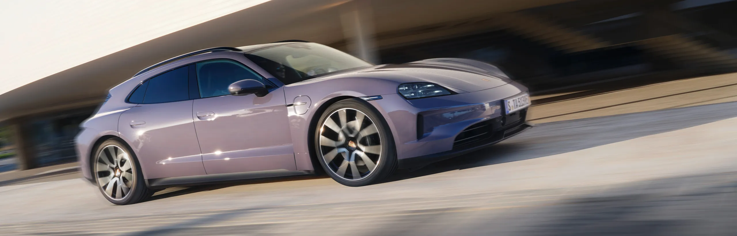 Porsche Taycan 4S Sport Turismo in Provence fährt durch Stadt. Blick auf die Seite.
