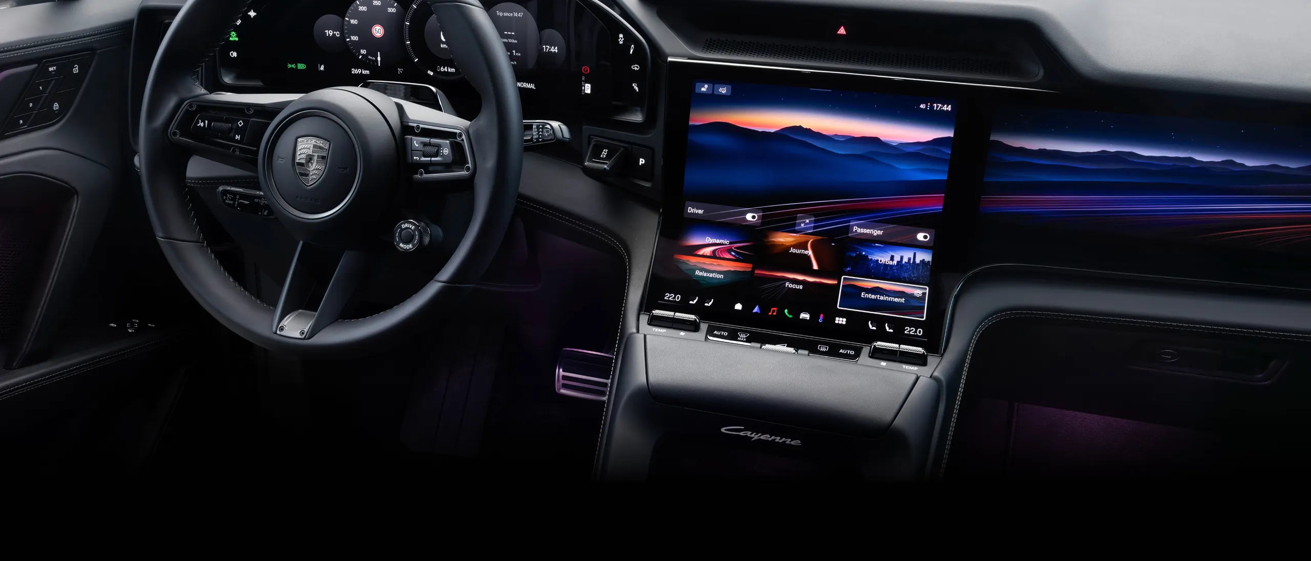 View into the cockpit of a Porsche Cayenne Turbo with focus on the steering wheel, display and centre console.
