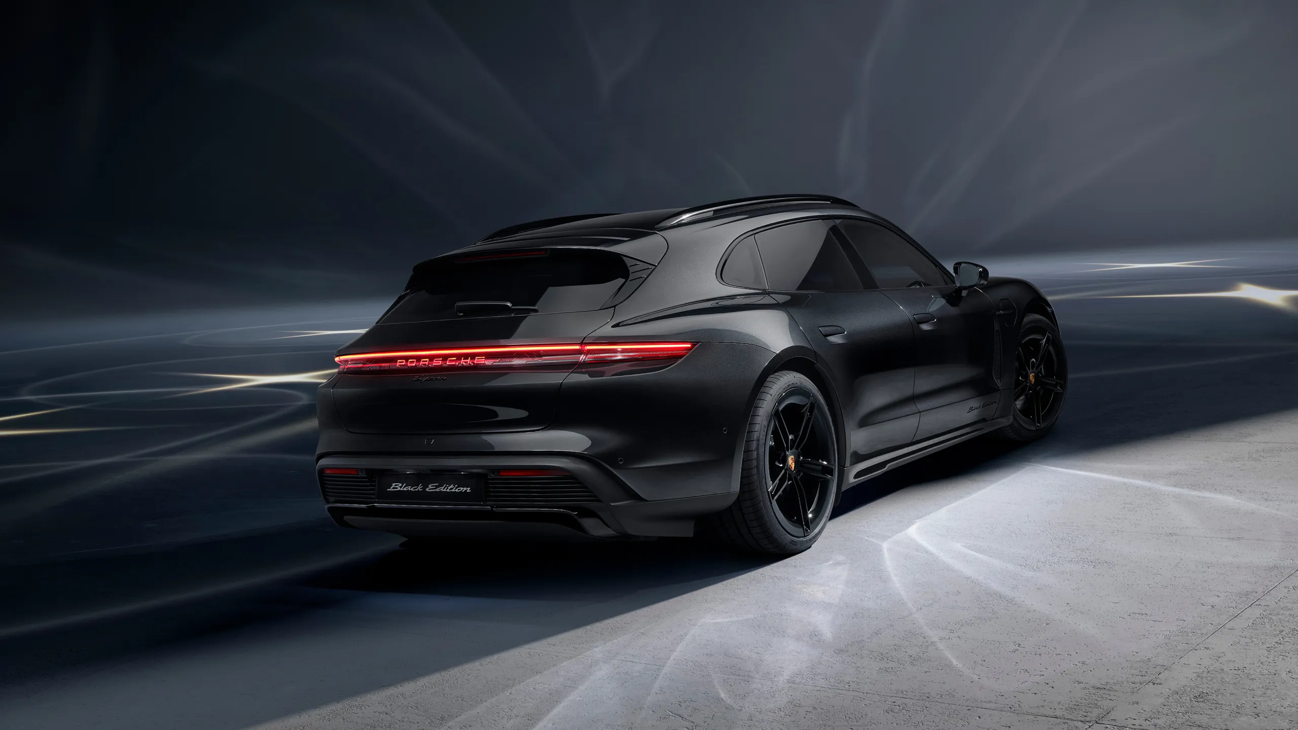 Rear view of a Porsche Taycan 4S Sport Turismo Black Edition in Jet Black Metallic.