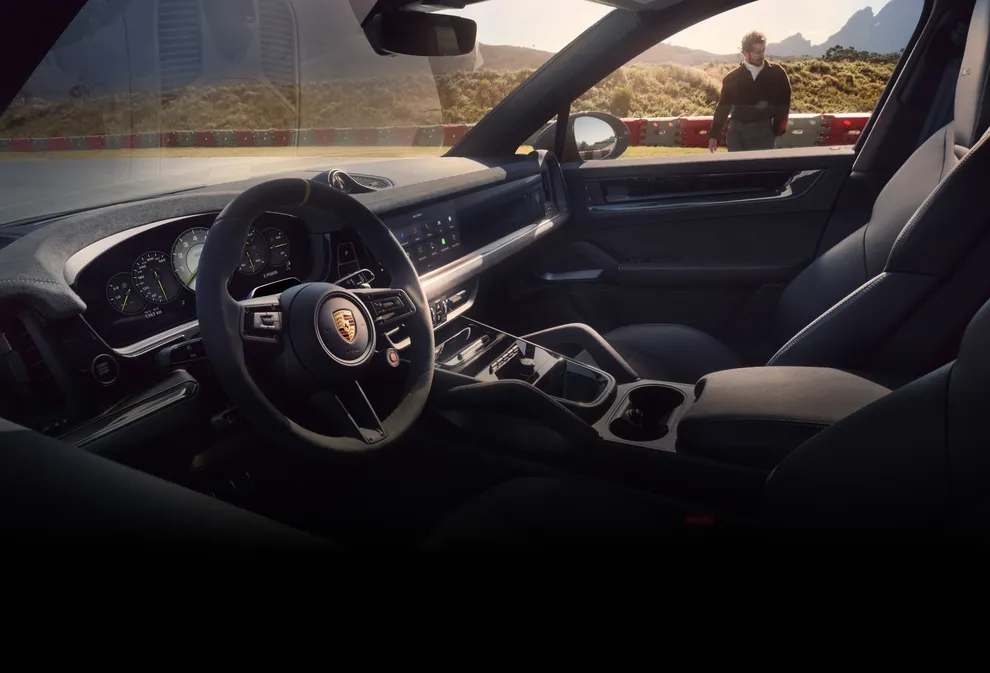 Interior del Porsche Cayenne Turbo E-Hybrid Coupé con paquete GT: vista del puesto de conducción a través de la ventana.
