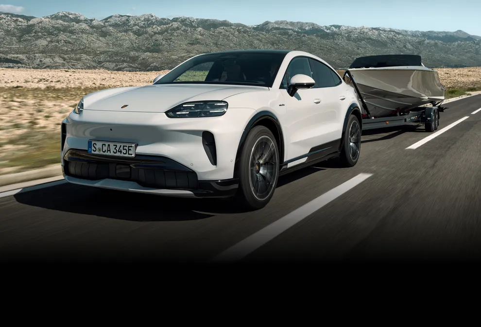 Ein Porsche Cayenne Turbo Coupé in Monteverdemetallic fährt auf einer Landstraße.