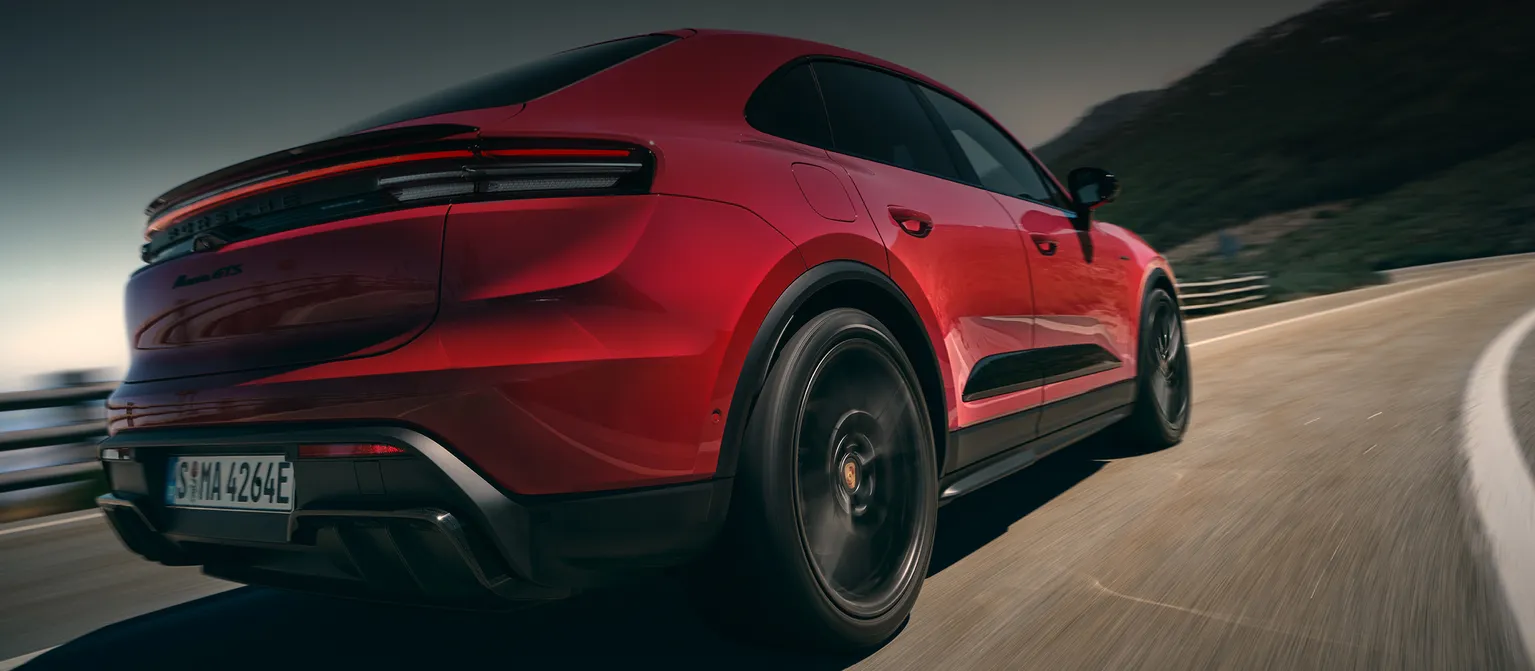 View of the rear end of a fast-moving Porsche Macan GTS in Carmine Red.