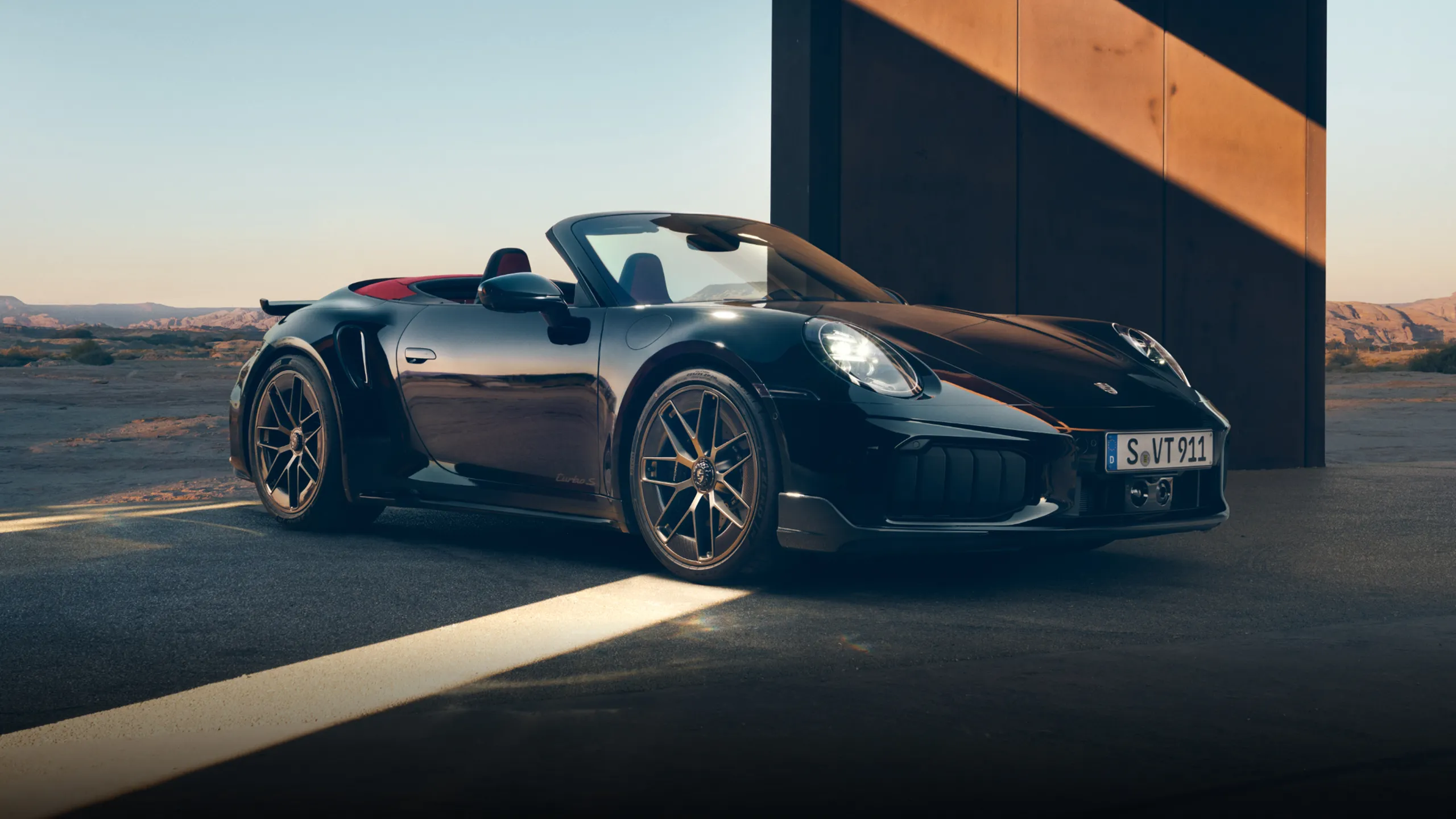 Sidovy av Porsche 911 Turbo S Cabriolet i Jet Black Metallic.