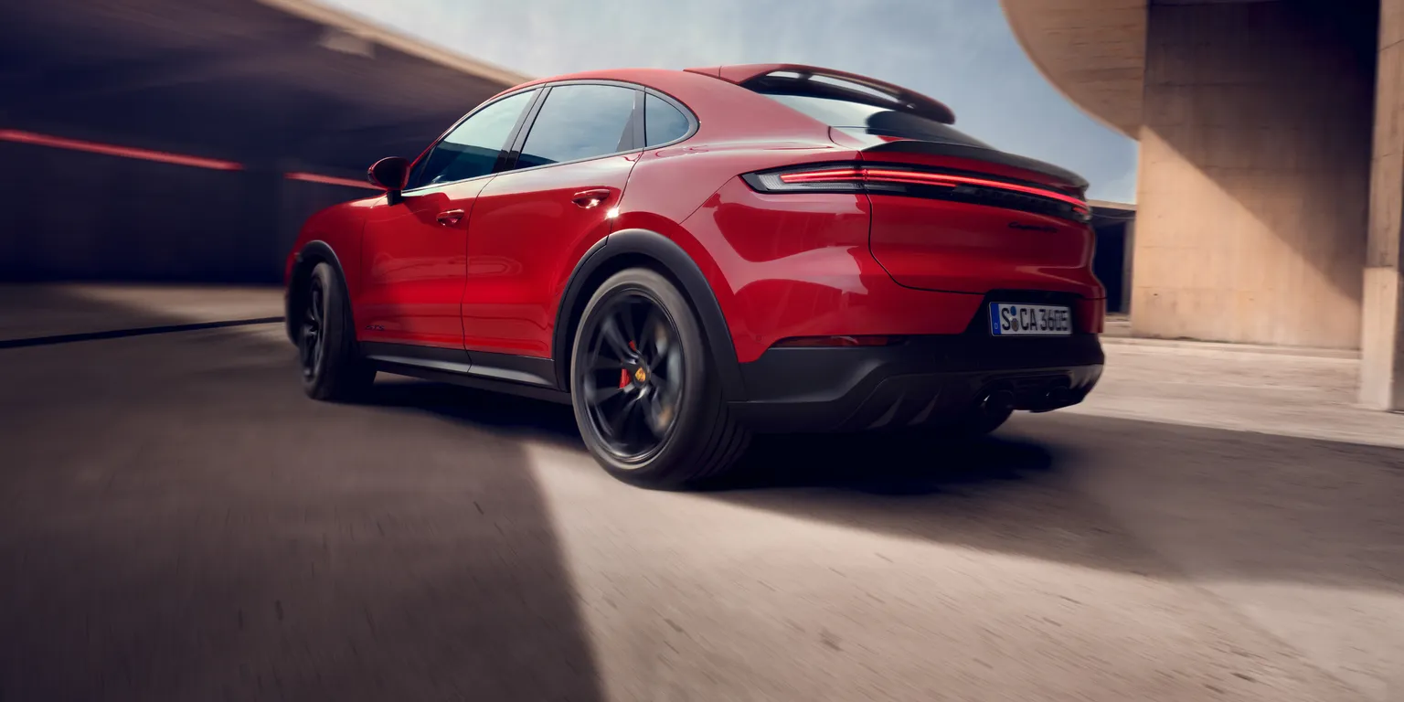 Blick von hinten auf Heck und Seite eines fahrenden Porsche Cayenne GTS Coupé.