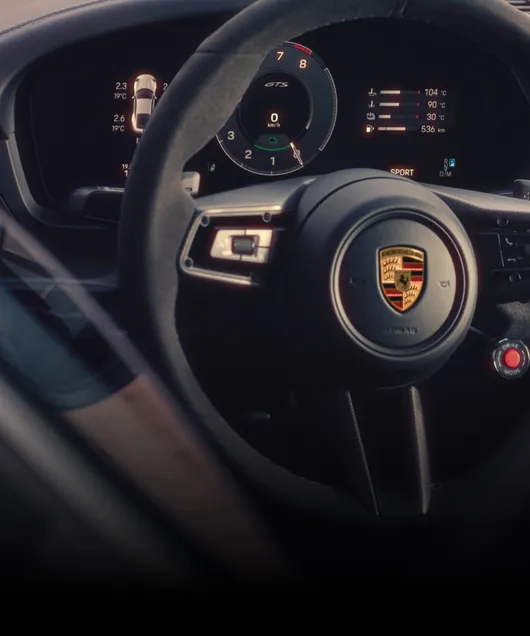 Interior of the Porsche 911 Carrera GTS. View of the steering wheel and the instrument cluster or curved display.