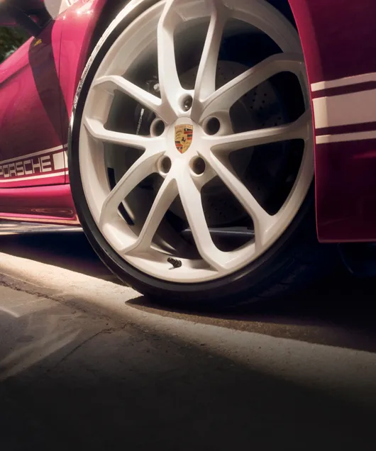 Detailed view of the 20-inch 718 Spyder wheels painted in White on the Porsche 718 Boxster Style Edition in Ruby Star Neo with White Contrast Package.