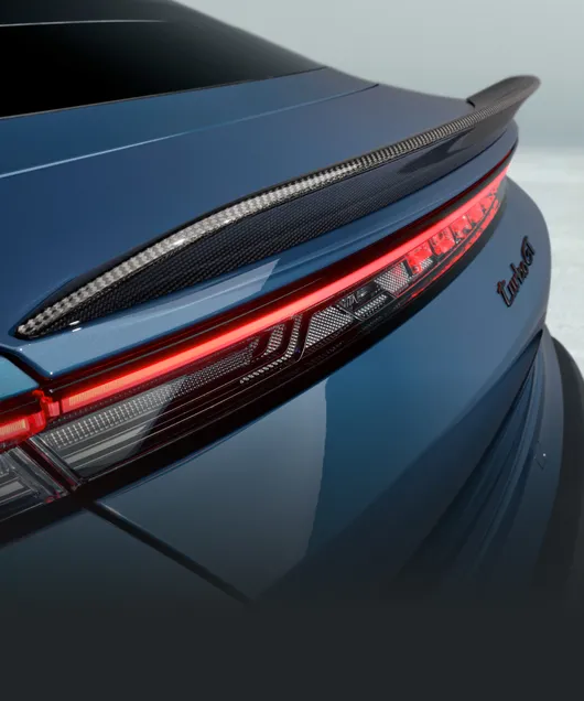 Porsche Taycan Turbo GT in Palebluemetallic. Blick auf den ausfahrbaren Heckspoiler mit Gurney.