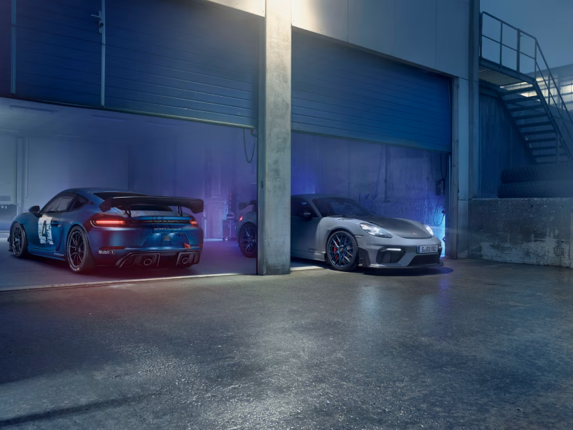Porsche 718 Cayman GT4 RS Clubsport et Porsche 718 Cayman GT4 RS côte à côte dans un garage.