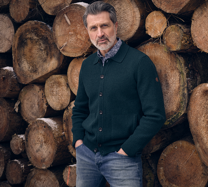 Man gekleed in een donkerblauw vest met een spijkerbroek