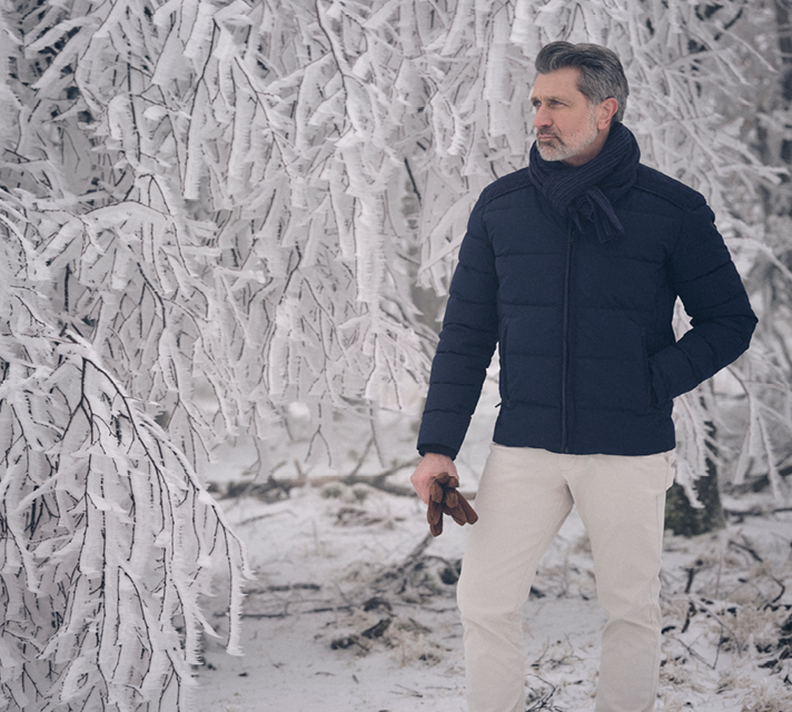 Man gekleed in donkerblauwe jas en beige broek