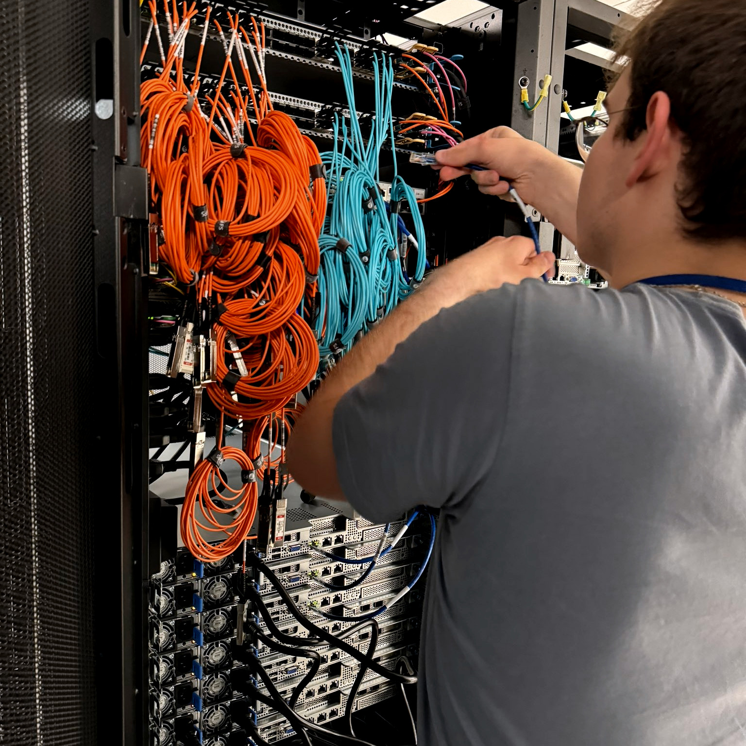 A DC2SCALE technician performs network cabling for Boosteroid servers in the DC2SCALE PAR3 Paris-Velizy data center, illustrating the infrastructure dedicated to cloud gaming.