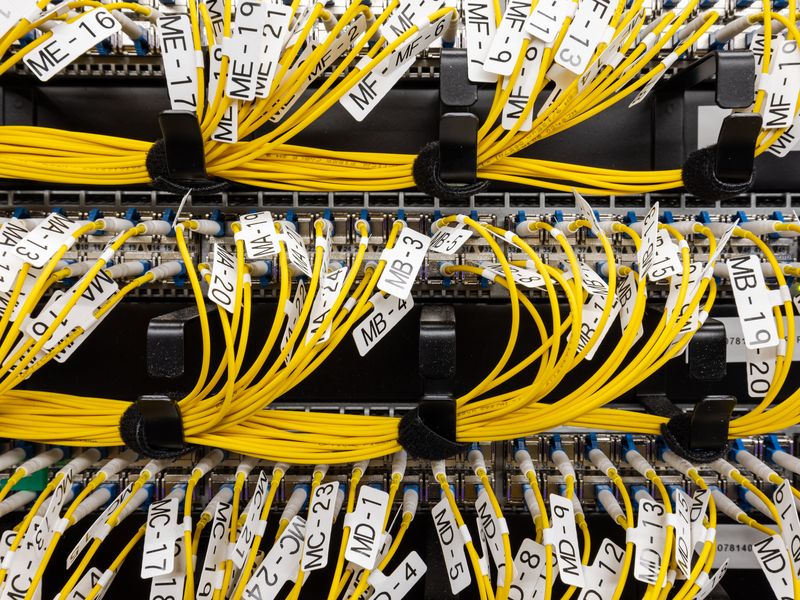 Many yellow fiber cables connected to a switch in rack dc2scale par2 velizy