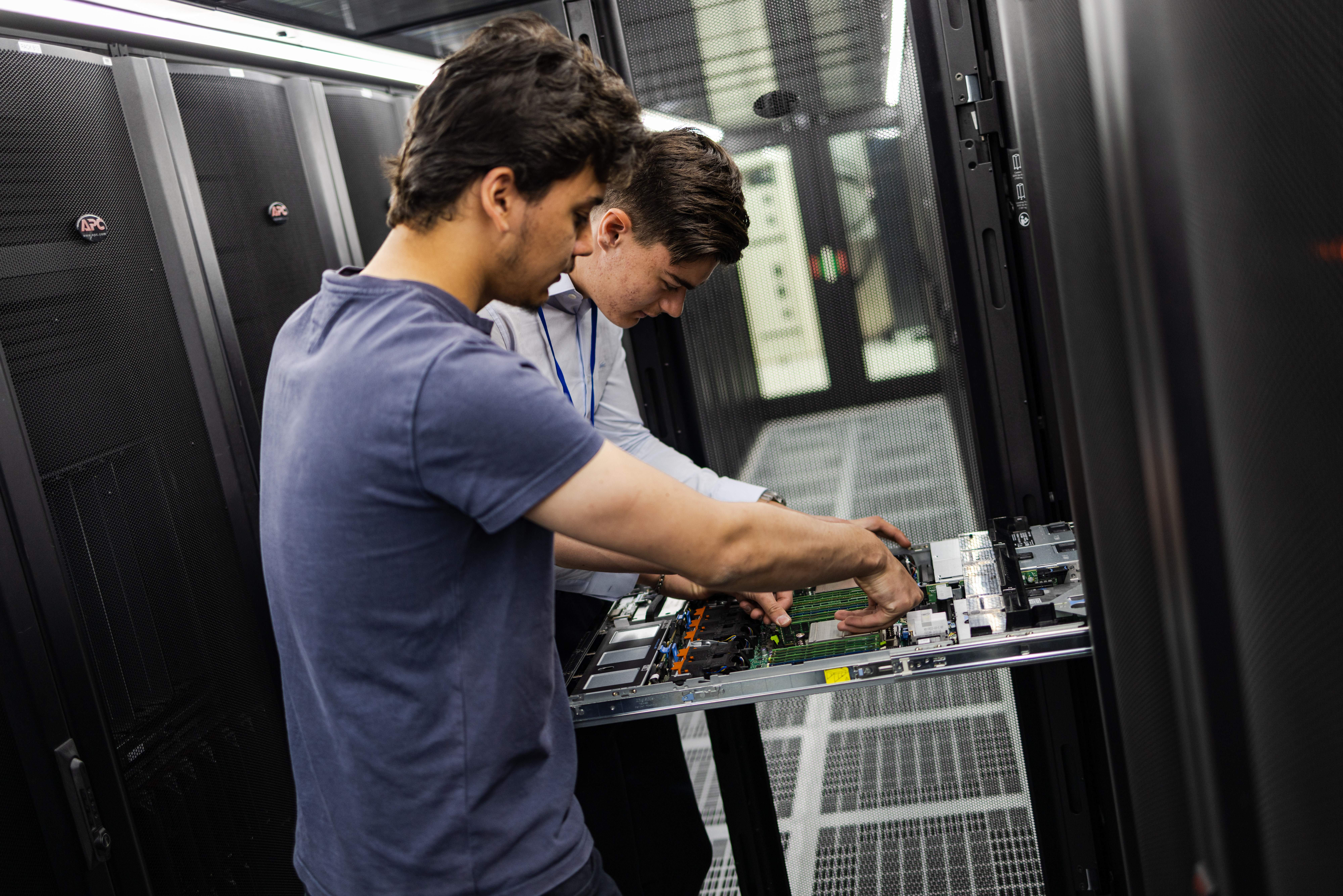 two persons working on a server in a cold corridor in the dc2scale par2 paris-velizy datacenter