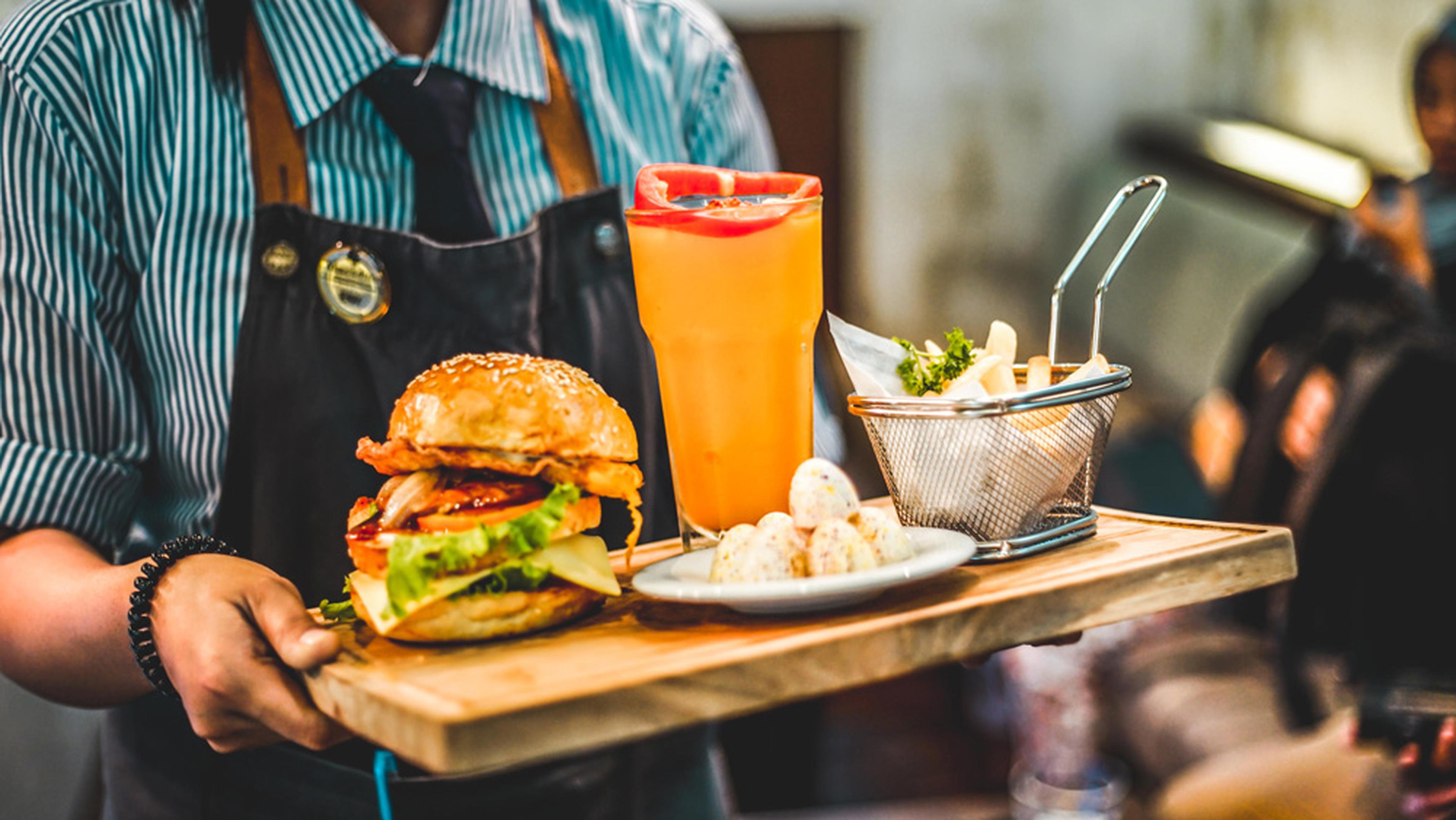 Waiter carrying a burger meal at a restaurant.