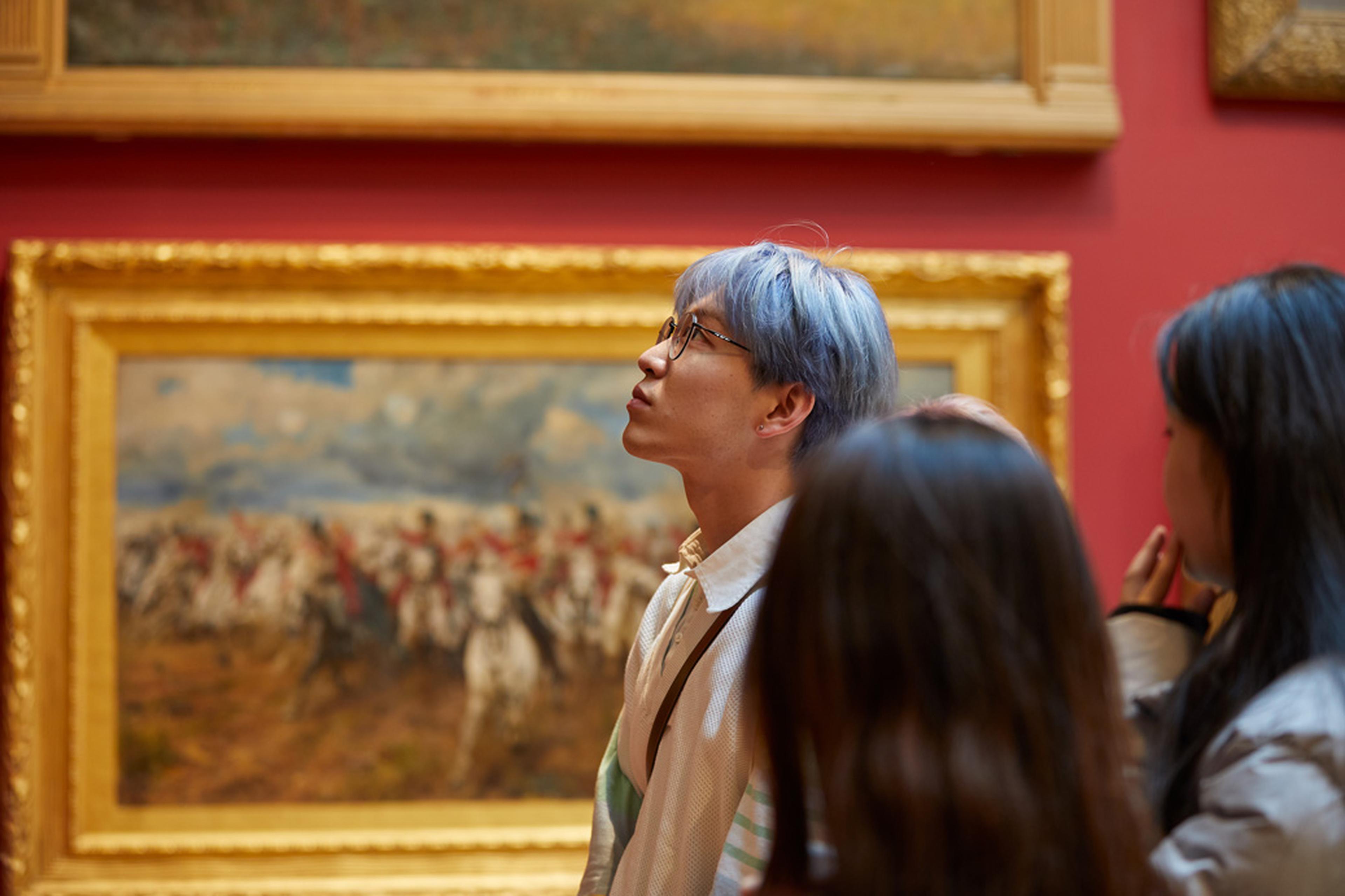 Asian people looking at art on a wall