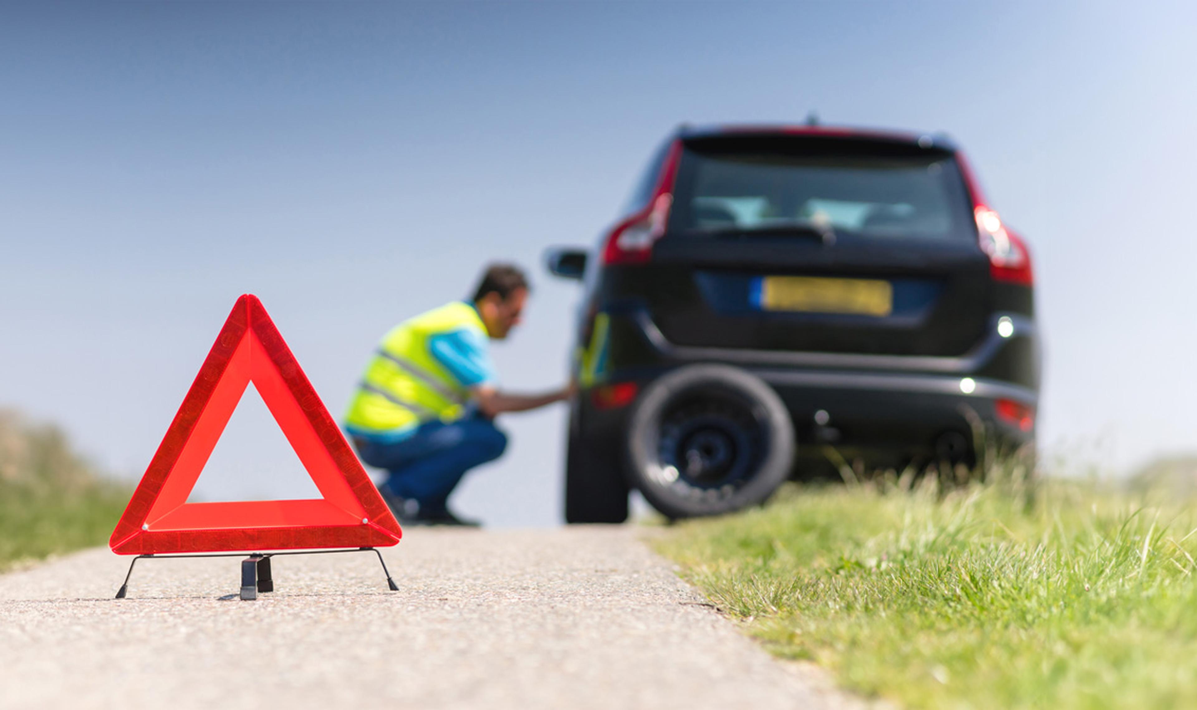 Mechanic fixing a car wheel on the roadside.
