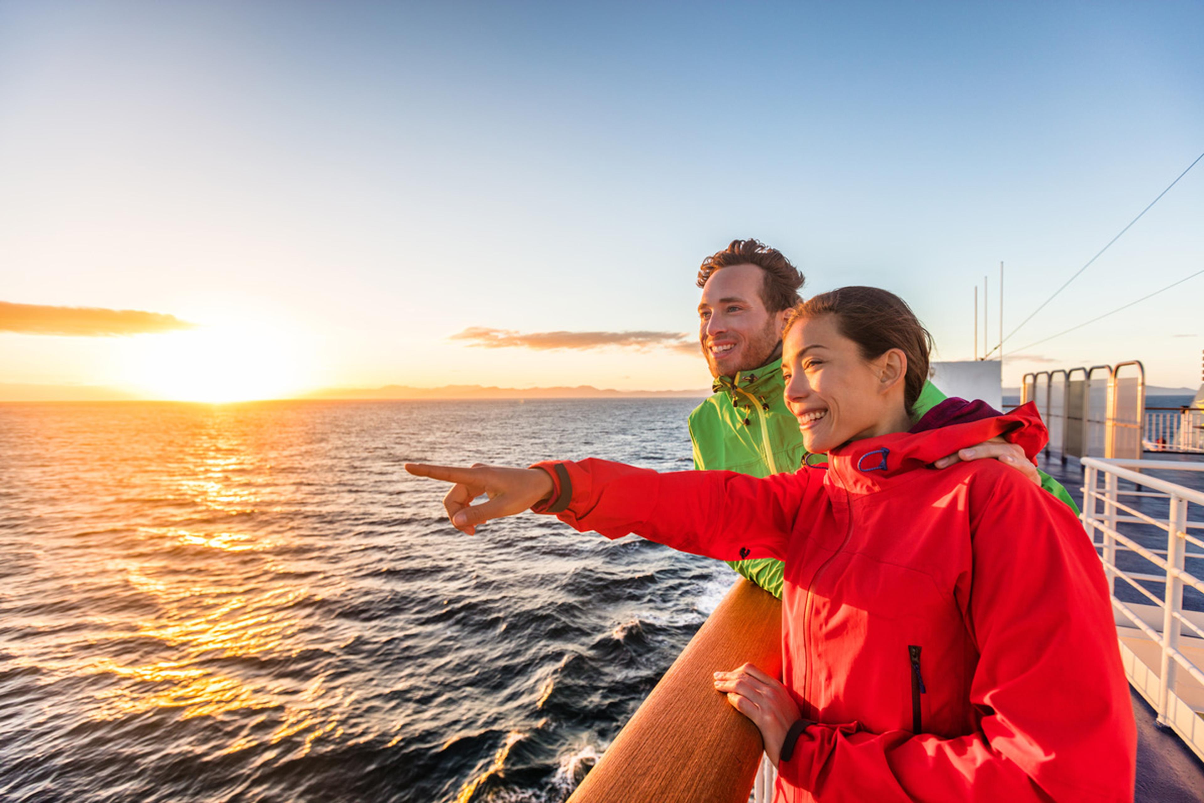 Two people on top tier of a passenger ferry.